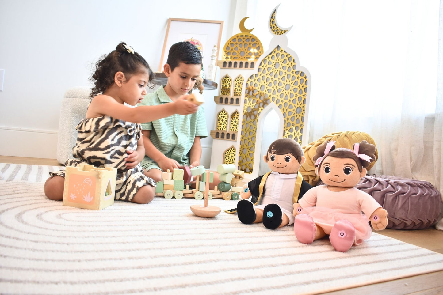 2 kids playing and with the muslim dolls are watching. Khaled doll holding prayer gesture. Faith-filled Islamic talking toy teaching Five Pillars of Islam.